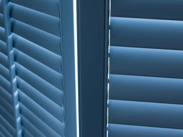 Close-up of deep blue plantation shutter louvres and central panel stiles.