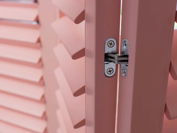 Close-up of the hinge and panel edge on coral blush plantation shutters.