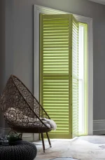 Lime green plantation shutters with one panel opened in a bright contemporary room.